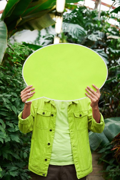 Person holding green speech bubble