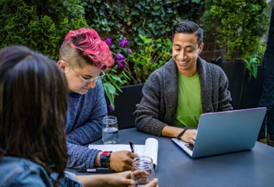 Three people collaborating outdoors